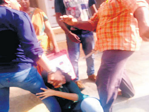 Raja Ram kicks his 25-year-old daughter in full public view on a road near Ulsoor Circle on Thursday afternoon. DH photos