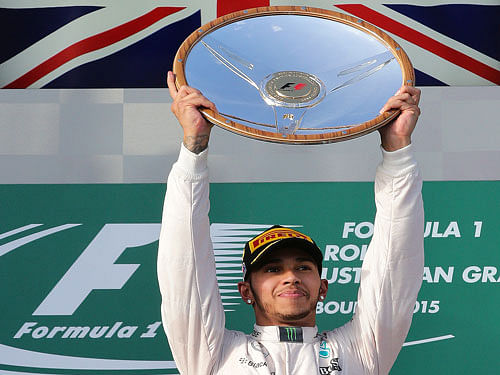 Mercedes driver Lewis Hamilton of Britain holds up the trophy on the podium after winning the season-opening Australian Formula One Grand Prix at Albert Park in Melbourne, Australia. AP Photo.