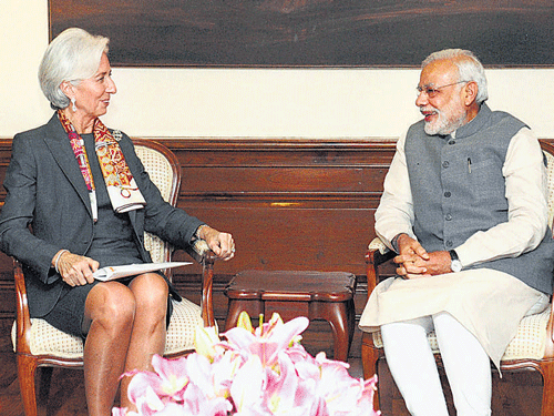 Prime Minister Narendra Modi talks to IMF Managing Director Christine Lagarde in New Delhi on Monday. PTI