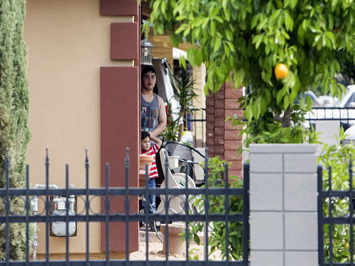 Residents look at police activity at one of the scenes of a multiple location shooting that has injured at least four people in Mesa, Arizona. A gunman killed one person and wounded five others in a shooting spree in Arizona, sparking an hours-long manhunt by SWAT teams before he was caught, police said. Reuters photo