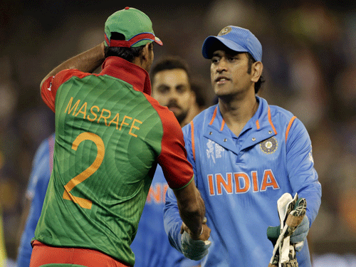 Bangladesh captain Mashrafe Mortaza (R) shakes hands with India's captain MS Dhoni after India's 109-run Cricket World Cup quarter final win over Bangladesh in Melbourne, March 19, 2015. REUTERS
