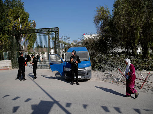 A woman walks past police officers standing guard outside the National Bardo Museum in Tunis, Thursday, March 19, 2015. AP photo