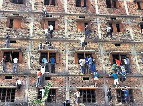 BLATANTCHEATING: Youths climbthe building of an examination centre to pass notes to candidates through the windowsduring a matriculation examination in Hajipur on Wednesday. PTI