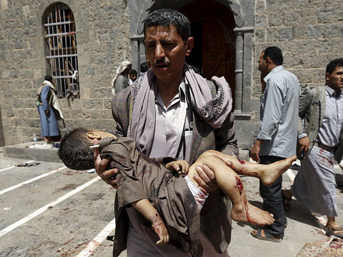 A man carries the body of a child out of the mosque which was attacked by a suicide bomber in Sanaa. Reuters image