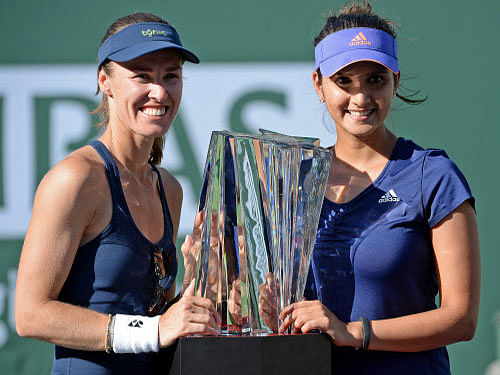 Martina Hingis (SUI) and Sania Mirza (IND) with the championship trophy after winning their doubles final match against Ekaterina Makarova (RUS) and Elena Vesnina (RUS) in the BNP Paribas Open at the Indian Wells Tennis Garden.