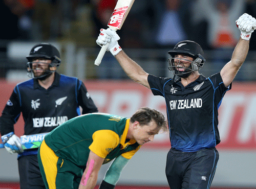 New Zealand's Grant Elliott raises his arms in celebration with teammate Dan Vettori, left,as South Africa's Dale Steyn reacts after they defeated South Africa by four wickets in their Cricket World Cup semifinal in Auckland, New Zealand. AP photo