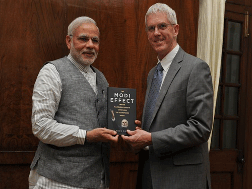 India Prime Minister Narendra Modi and British Author Lance Price with the book 'The Modi effect: Inside Narendra Modi's campaign to transform India'. Image Courtesy: Twitter