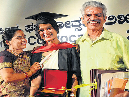 Mangala Gowri K of the Bangalore Medical College and Research Institute poses with her parents at the convocation of Rajiv Gandhi University of Medical Sciences in Bengaluru on Wednesday. She bagged five gold medals. DH PHOTO