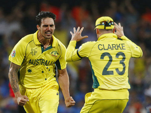 Australian bowler Mitchell Johnson (L) reacts alongside captain Michael Clarke after wicket keeper Brad Haddin caught out India's Virat Kohli for one run during their Cricket World Cup semi-final match in Sydney, March 26, 2015. REUTERS