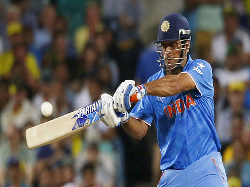 India's MS Dhoni hits the ball for four runs during his Cricket World Cup semi-final match against Australia in Sydney. Reuters Photo.