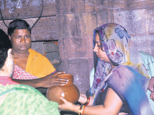 The Bhubaneswas couple receives the first pot of water from a holy well at the Lingaraj temple. DH Photo