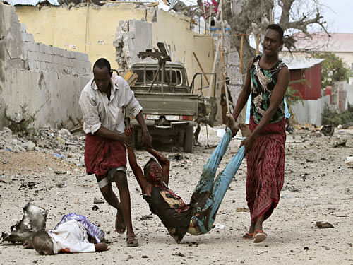 Residents evacuate an injured boy after Islamist group al Shabaab attacked Maka Al-Mukarama hotel in Mogadishu, March 27, 2015. Islamist militants blasted their way into a popular hotel in the Somali capital Mogadishu on Friday, killing at least seven people and trapping government officials inside, police and witnesses said. REUTERS