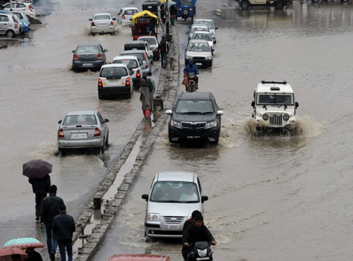 Vehicles move along a flooded road in Srinagar after heavy rainfall on March 29, 2015. AFP file photo