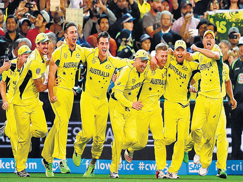 the yellow surge: Australian players rush on to the field after their World Cup triumph over New Zealand at the Melbourne Cricket Ground on Sunday. Australia won the final by seven wickets. reuters