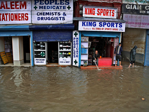Kashmiri shopkeeper tries to remove water from inside a sports goods shop following heavy rains in Srinagar, Indian controlled Kashmir, Sunday, March 29, 2015. Heavy rains have been reported in several parts of the Kashmir valley. AP Photo