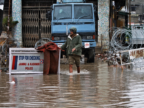 An Indian paramilitary soldier walks through a flooded street following heavy rains in Srinagar, Indian controlled Kashmir, Sunday, March 29, 2015. Heavy rains have been reported in several parts of the Kashmir valley. AP Photo