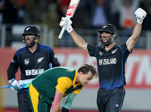 Grant Elliott raises his arms in celebration with teammate Dan Vettori, left,as South Africa's Dale Steyn reacts after they defeated South Africa by four wickets in their Cricket World Cup semifinal in Auckland. AP file photo