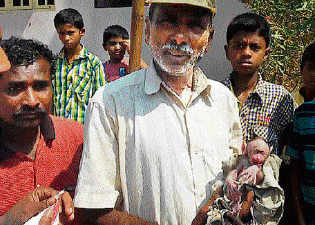 Jagadish, a civic worker, with the baby monkey which he and others in the rescue team helped save. DH&#8200;Photo