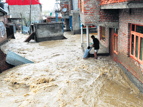 A man is pulled out to safety as flood waters sweep residential areas in Srinagar; PTI Photo