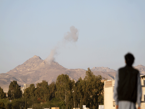 Man looks on as smoke billows from military barracks in the Jabal al-Jumaima mountain following an air strike near Sanaa. Reuters Photo