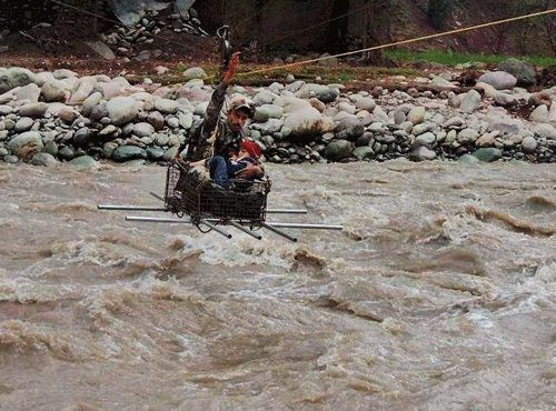 An army person rescues a boy from flash floods in Poonch, Jammu and Kashmir on Monday. PTI Photo