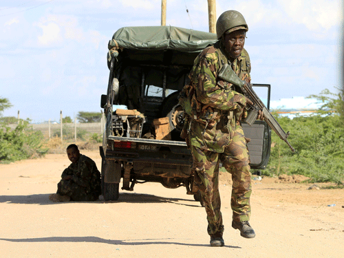 A Kenya Defense Force soldier runs for cover near the perimeter wall where attackers are holding up at a campus in Garissa. Reuters photo
