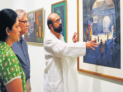 picture perfect Artist Eby N Joseph explains one of his paintings to visitors at the  Karnataka Chitrakala Parishath. DH PHOTO