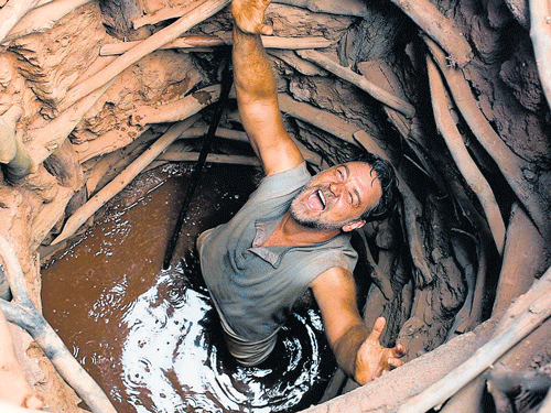 Joshua Connor (Russell Crowe) celebrates after digging up a well and finding water.