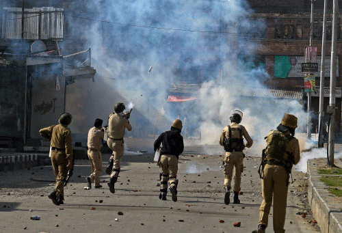 Policemen fire teargas shells towards protesters during an agitation against the arrest of Masarat Alam in Srinagar on Friday. PTI Photo