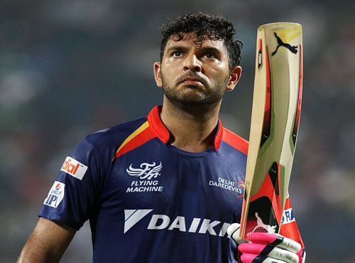 Delhi Daredevils player Yuvraj Singh raises his bat as he walks back to the pavilion after getting out during an IPL T20 match against Kings XI Punjab in Pune on Wednesday. PTI Photo