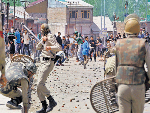 Angry protesters throwstones at the police during clasheswhich erupted after the killing of a 16-year-old youth in Srinagar on Saturday. PTI