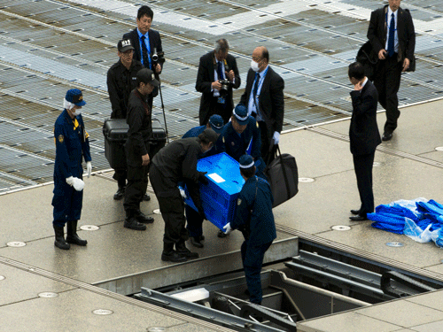 Officials carry a blue box that local media reported contains a drone from the rooftop of Prime Minister Shinzo Abe's official residence in Tokyo. Reuters Photo