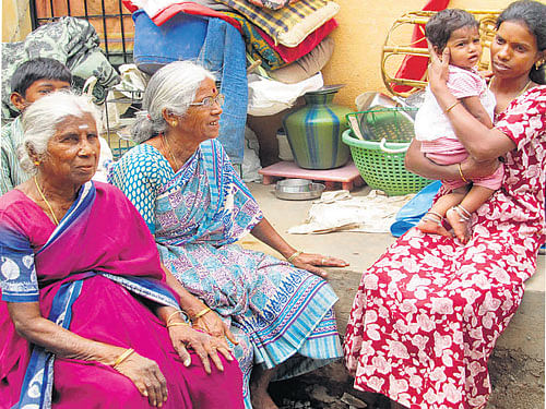 Family members with their belongings after their house was razed in an eviction drive carried out at Allalasandra Lake near Yelahanka on Saturday.  DH PHOTO