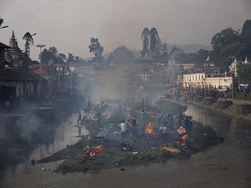 Flames rise from burning funeral pyres during the cremation of victims of Saturday's earthquake, at the Pashupatinath temple on the banks of Bagmati river, in Kathmandu. AP photo