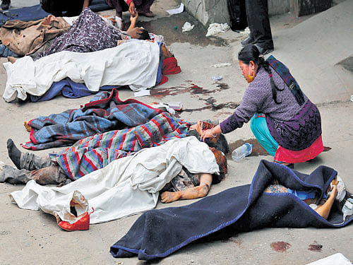 A woman tries to identify a body outside a hospital  in Kathmandu, Nepal on Sunday. Reuters