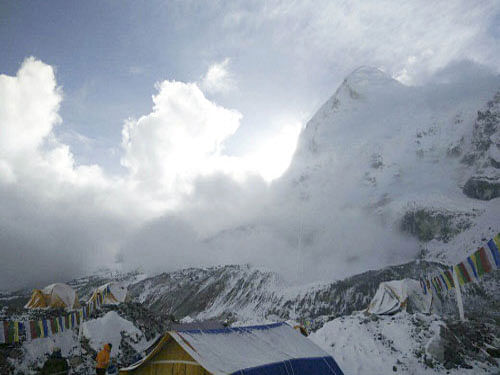This photo provided by Azim Afif, shows a small avalanche on Pumori mountain as seen from Everest Base Camp, Nepal. On Saturday, a large avalanche triggered by Nepal's massive earthquake slammed into a section of the Mount Everest mountaineering base camp, killing a number of people and left others unaccounted for. AP