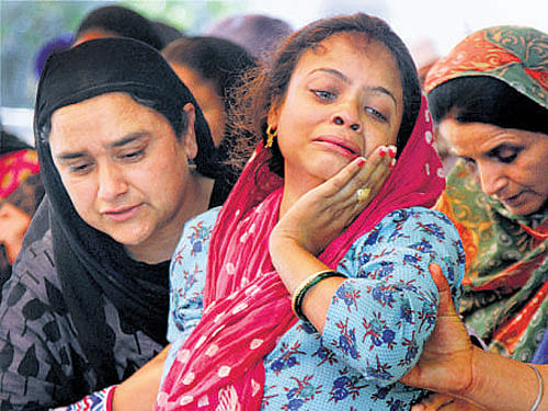 Relatives of a man who died in the earthquake, grieve in Jammu on Sunday. PTI