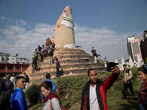 A man takes a selfie at the historic Dharahara Tower, a city landmark, that was damaged in Saturday's earthquake in Kathmandu. AP Photo