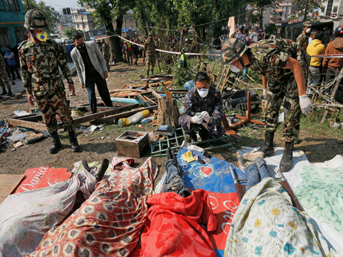 Rescue teams' members identify bodies dug out of the collapsed Sitapyla church in Kathmandu, Nepal, Monday, April 27, 2015. A strong magnitude 7.8 earthquake shook Nepal's capital and the densely populated Kathmandu Valley on Saturday, causing extensive damage with toppled walls and collapsed buildings.  AP Photo.