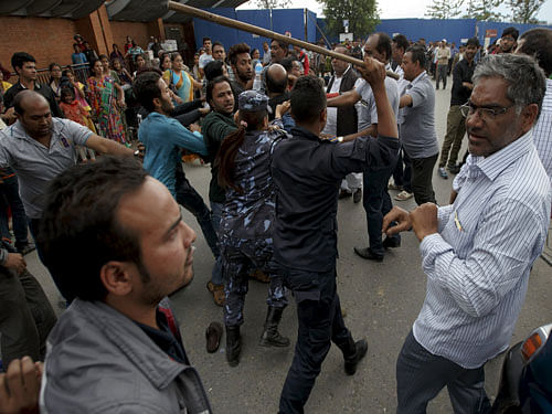 Airport officers stop Indians from fighting during a queue for an aircraft back to their country outside Nepal's Tribhuvan International Airport a day after a 7.9 magnitude earthquake, in Kathmandu. Reuters Photo