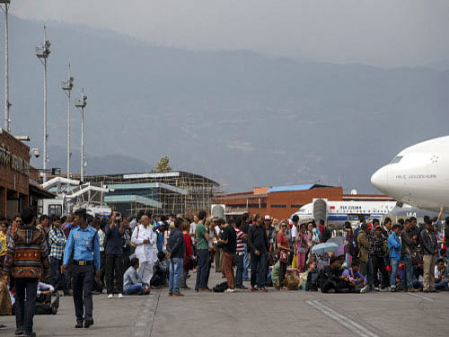 Tourists gather inside Nepal's Tribhuvan International Airport a day after a 7.9 magnitude earthquake, in Kathmandu, Nepal. Air services to quake-devastated Nepalese capital Kathmandu from India returned to normal today but shortage of parking bays at the airport was preventing the carriers to operate more flights to evacuate stranded people.