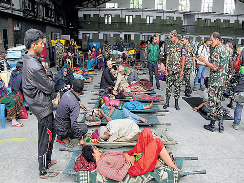 Victims of Saturday's earthquake wait for ambulances to take them to hospitals after being evacuated at the airport in Kathmandu on Monday. AP