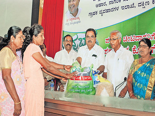 District in-charge Minister B Ramanath Rai gives away free rice to beneficiaries at Zilla Panchayat in Mangaluru on Friday. MLA J R Lobo, Zilla Panchayat President Asha Thimmappa Gowda and others look. DH photo