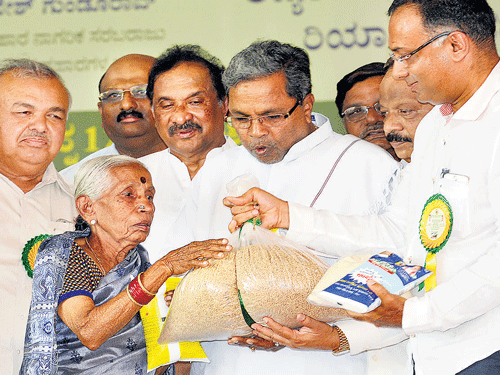 Chief Minister Siddaramaiah gives food grains, edible oil and salt to a woman to mark the  inauguration of free ration scheme to BPL and Antyodaya cardholders in Bengaluru on  Friday. Transport Minister Ramalinga Reddy, Home Minister K J George, Information Minister Roshan Baig and Food and Civil Supplies Minister Dinesh Gundu Rao are also seen. dh Photo