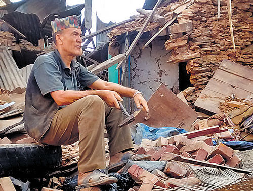 A man sits amid the debris of his shop in Sindhupalchok  district. DH Photo/Kalyan Ray