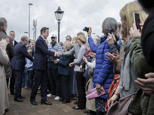 British Prime Minister David Cameron, center left, greets members of the public as he arrives to make a speech at the Ambleside Sports Club in Nuneaton, England. Over 50 candidates of Indian origin are contesting in Thursday's British general election, the outcome of which should be known by Friday morning. AP photo