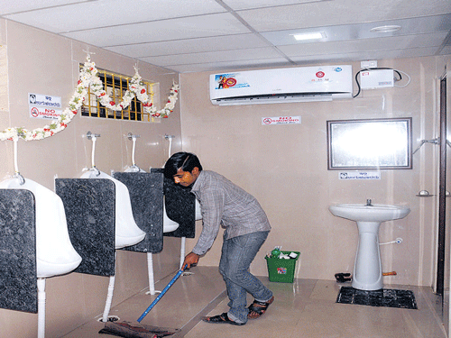 An attendant cleans the newly opened air conditioned toilet  between KSRTC bus stand and City railway station on Gubbi Thotadappa Road in Majestic area. DH photo