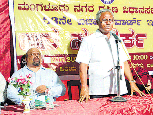 Mangaluru South MLA J R Lobo speaks during  the 'Jana Samparka Sabhe' at Government Primary School of Bajal on Tuesday. Residents submit their woes to the MLA during the meeting. MCC Joint Commissioner Gokuldas Naik, Assistant Commissioner Ashok and others look on. DH Photo