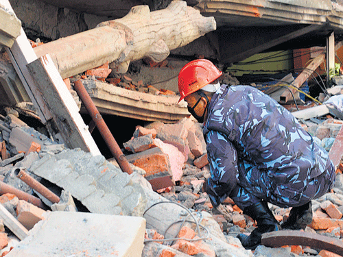 A Nepalese rescue team official searches for victims in a  collapsed house in Kathmandu. AFP