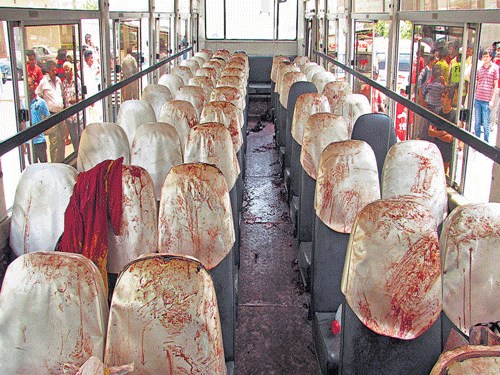 Macabre act: People look at the bus, with blood-stained seats, targeted by attackers in Karachi, Pakistan, on Wednesday. AP